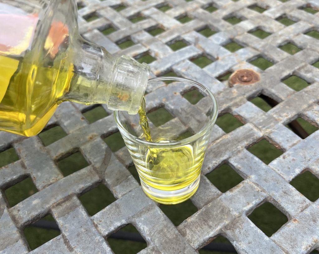 Licor de hierbas being poured from the bottle into a shot glass