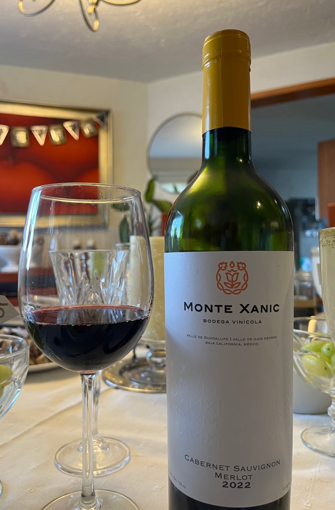 lose-up of Monte Xanic Cabernet–Merlot bottle beside a glass of red wine